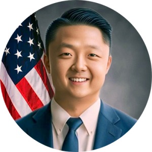 a man smiling in front of the American flag